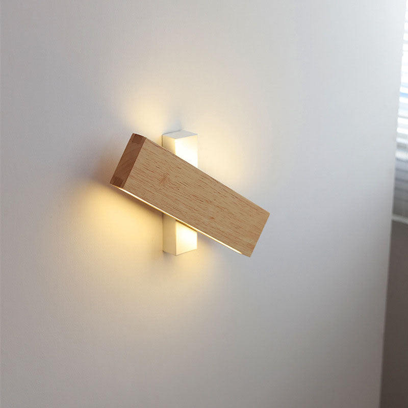 Wooden bar rotated horizontally across a white mount, with warm light glowing above and below the white support. 9