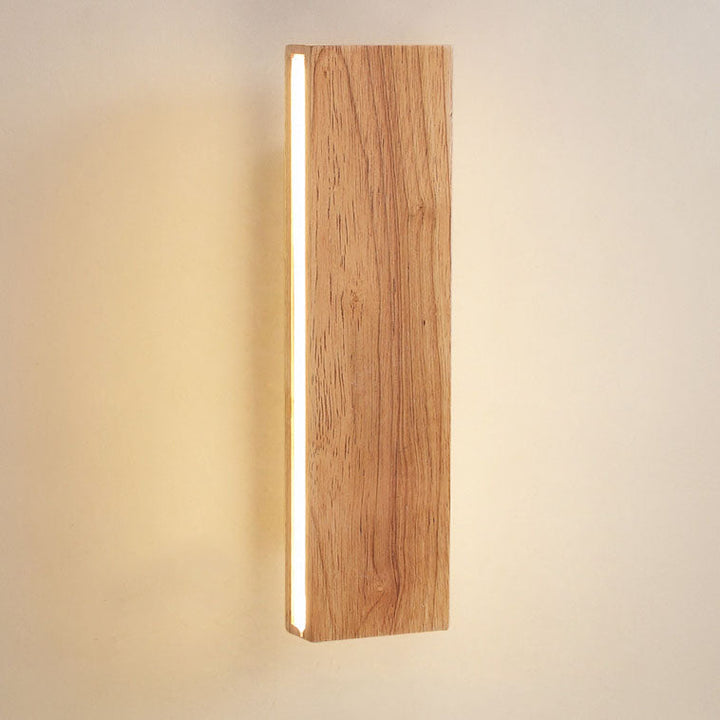 Close-up of the vertical wooden lamp showing the pronounced wood grain and a glowing light strip along its side. 14