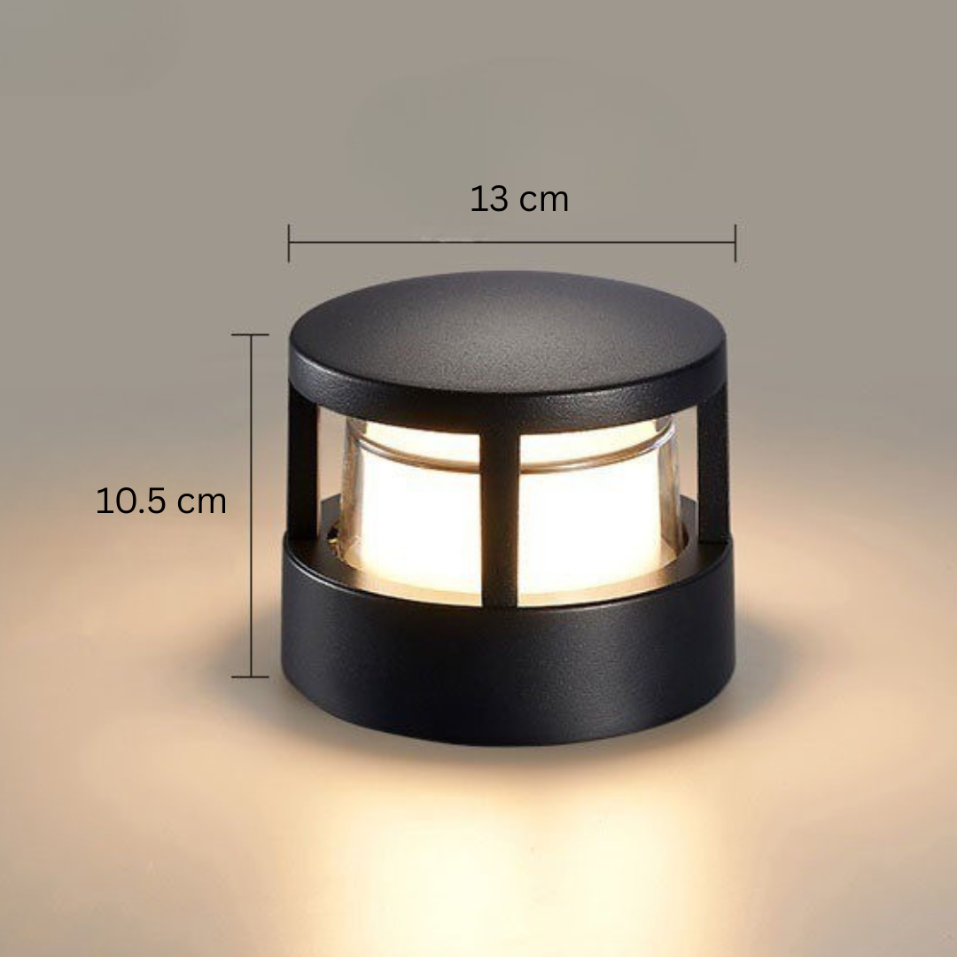 Okrągła lampa z płaskim daszkiem, na zdjęciu opisane wymiary: 13 cm szerokości i 10,5 cm wysokości. 14