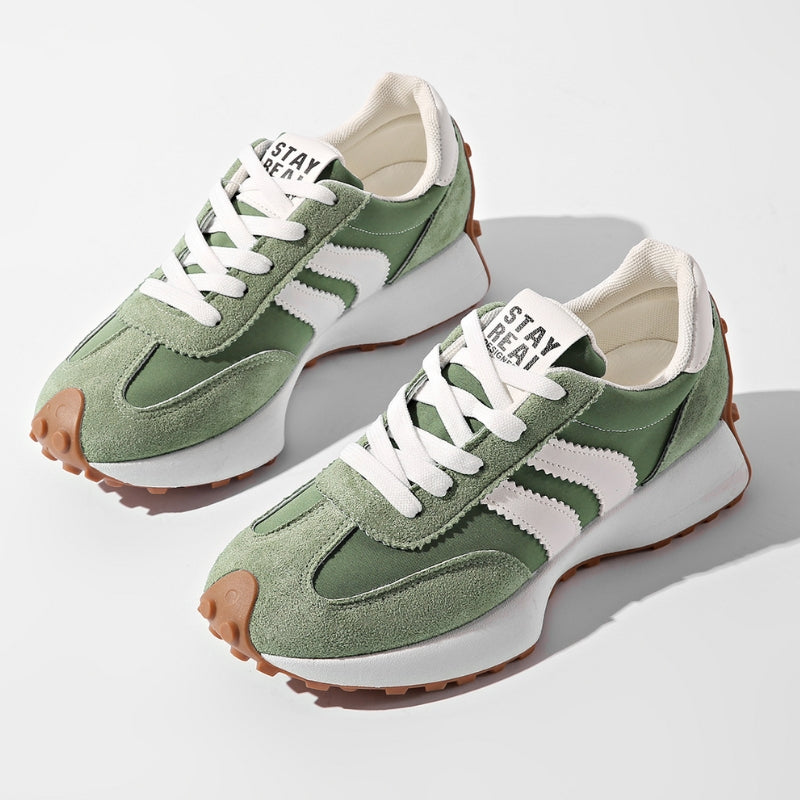 Zielone zamszowe sneakersy z białymi paskami i karmelową podeszwą, ułożone parą na jasnym tle 1