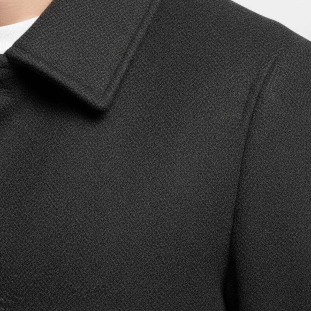 Zbliżenie na kołnierz, ramię i fakturę ciemnej tkaniny płaszcza noszonego przez modela 7