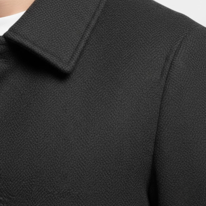 Zbliżenie na kołnierz, ramię i fakturę ciemnej tkaniny płaszcza noszonego przez modela 7