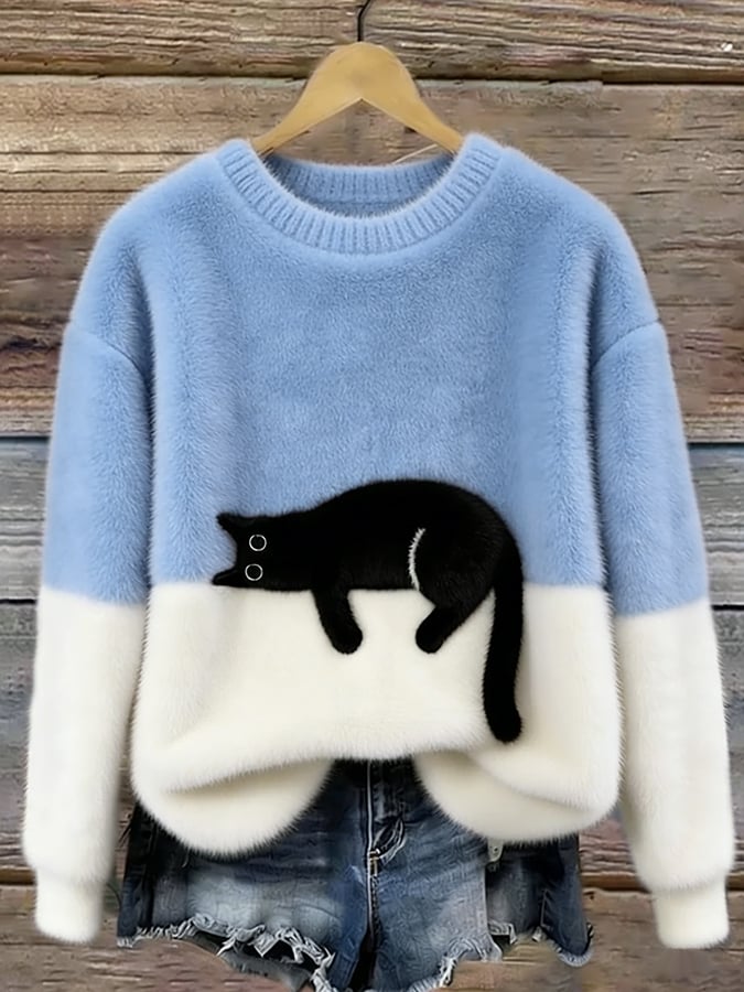 Puszysty sweter w kolorze jasnoniebieskim z białym dołem i czarnym kotem, na drewnianym wieszaku 1