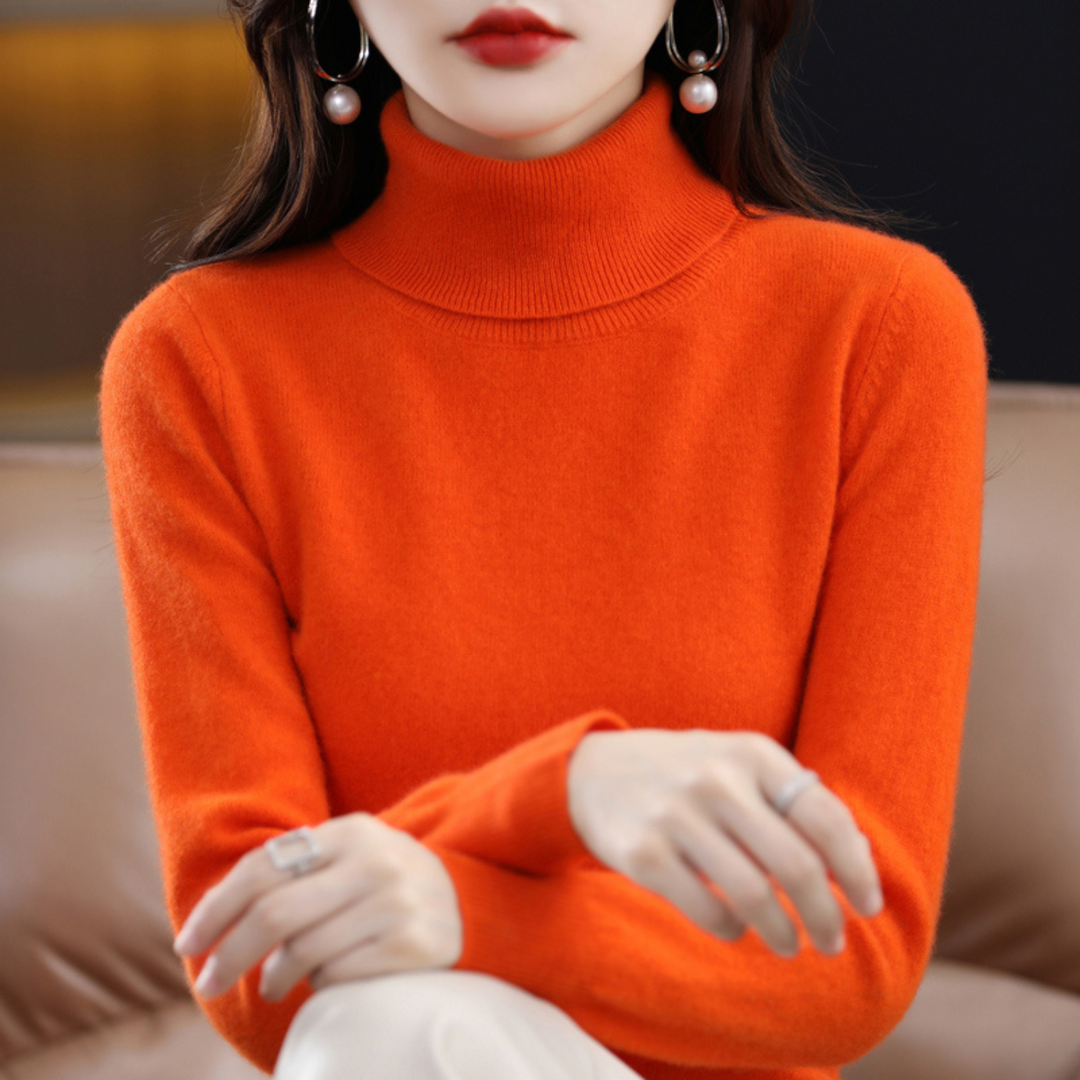 Pomarańczowy sweter z golfem na modelce z rękami skrzyżowanymi na kolanie, widoczny gruby kołnierz. 10