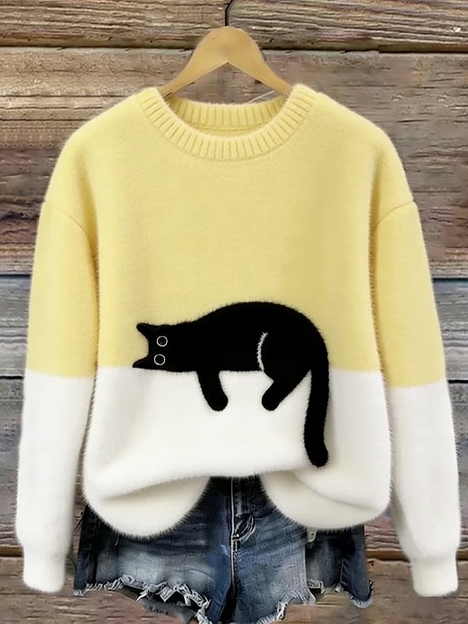 Puszysty sweter w kolorze jasnożółtym z białym dołem i czarnym kotem, na drewnianym wieszaku 7