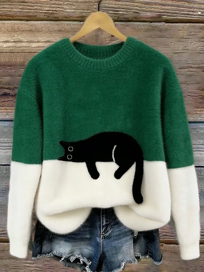 Puszysty sweter w kolorze zielonym z białym dołem i czarnym kotem, na drewnianym wieszaku 4