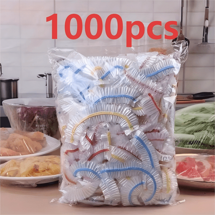 Torba z kolorowymi pokrywkami na blacie kuchennym, w tle talerze z mięsem, makaronem i warzywami przykryte folią. 3
