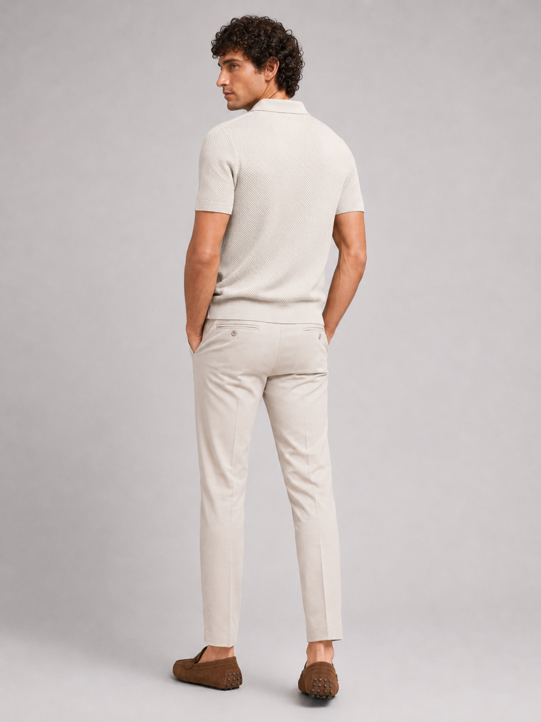 Jasnobeżowa koszulka polo od tyłu, model w jasnych spodniach i brązowych mokasynach 19