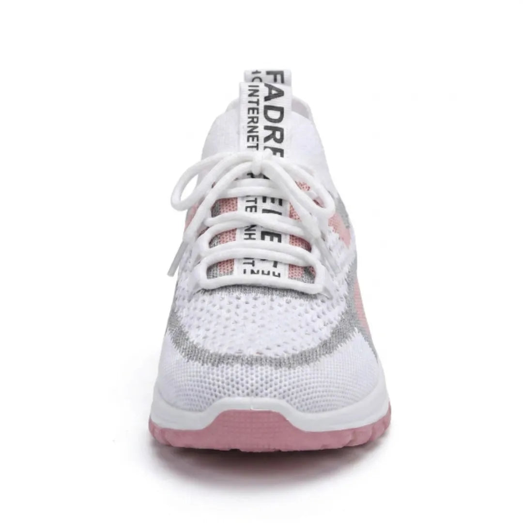 Biały sneaker z siateczki widziany od przodu: sznurowanie, różowo-szare wstawki, szeroki nosek i różowa podeszwa. 26
