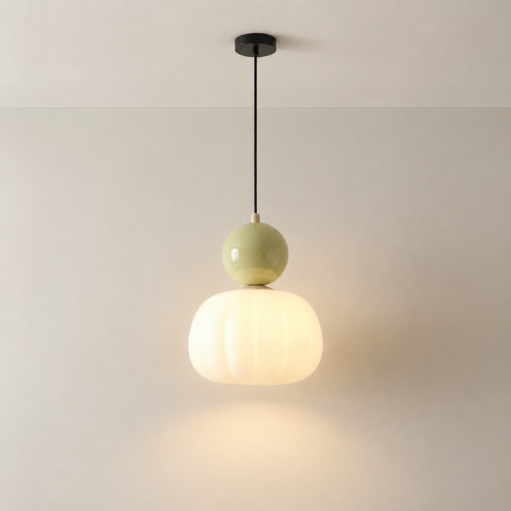 Pojedyncza lampa z jasnozieloną kulą i ryflowanym kloszem na czarnym kablu, zawieszona przy jasnej ścianie 4