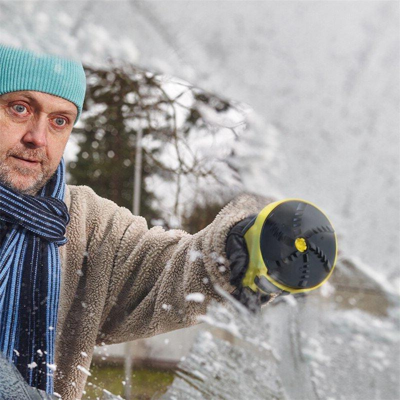 Mężczyzna w czapce i szaliku zdejmuje śnieg z szyby, widać spód urządzenia z obrotową głowicą 3