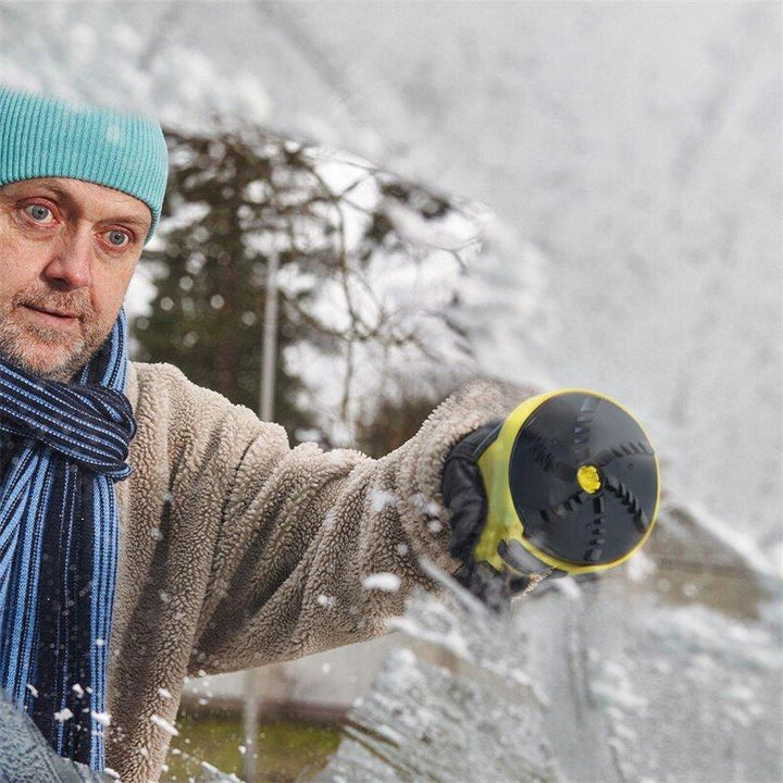 Mężczyzna w czapce i szaliku zdejmuje śnieg z szyby, widać spód urządzenia z obrotową głowicą 3