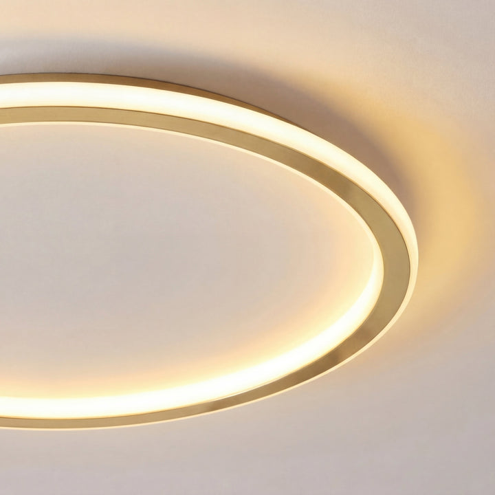 Zbliżenie na złotą oprawę i świecący pierścień lampy, widoczne ciepłe, rozproszone światło 2