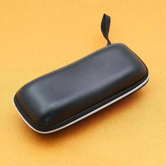 Czarne etui na okulary z zamkiem błyskawicznym i paskiem leży na pomarańczowym tle 11