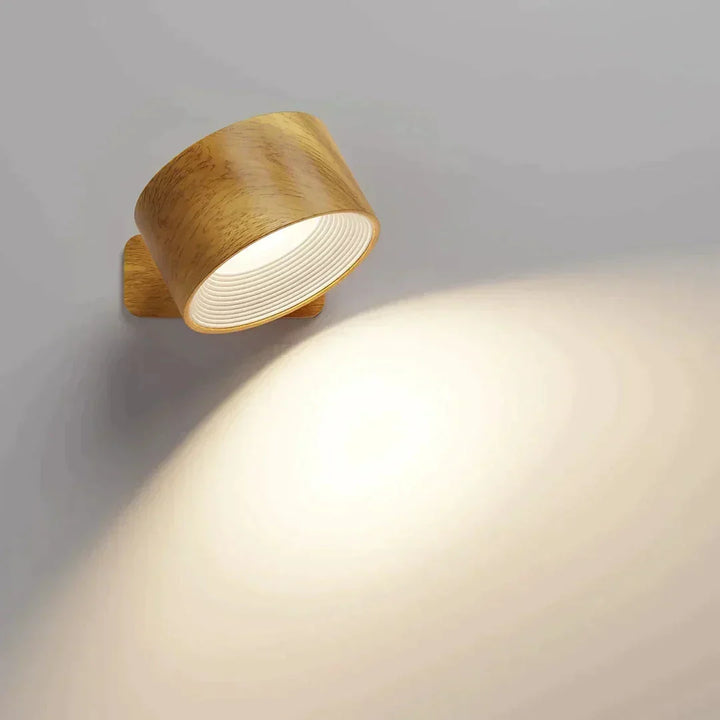 Lampa w drewnopodobnej obudowie na szarej ścianie, światło pada ukośnie w dół 9