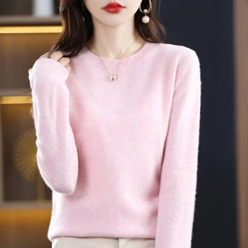 Różowy sweter z okrągłym dekoltem na modelce, która dotyka włosów dłonią 23