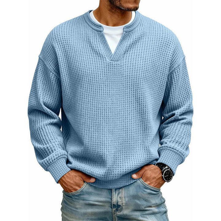 Jasnoniebieski sweter z dzianiny waflowej na modelu w jeansach, ujęcie z przodu z białą koszulką pod spodem. 6