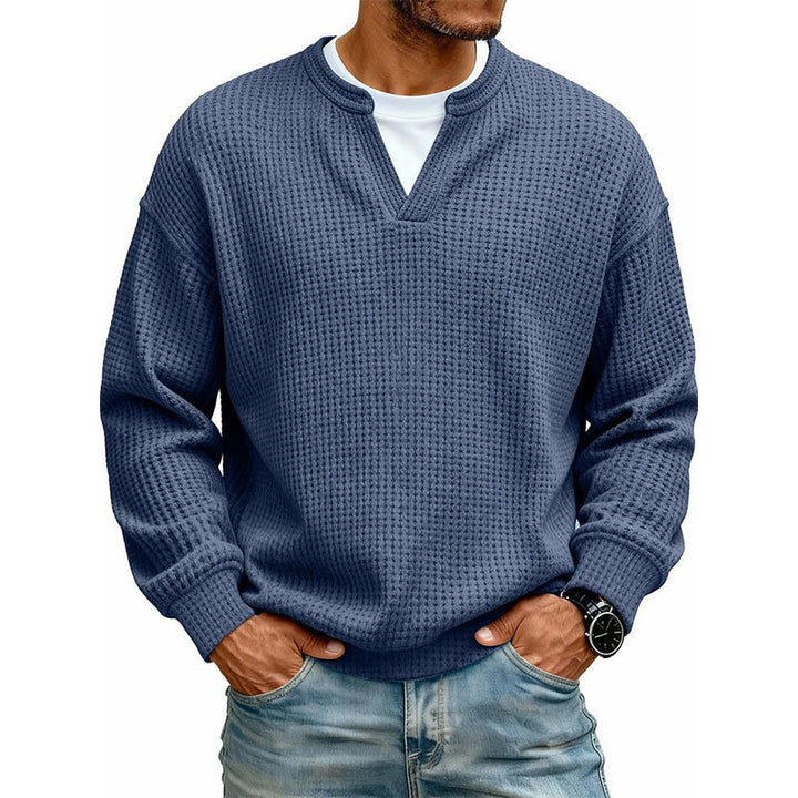 Granatowy sweter waflowy z wycięciem w serek na modelu, z białą koszulką i jeansami. 7