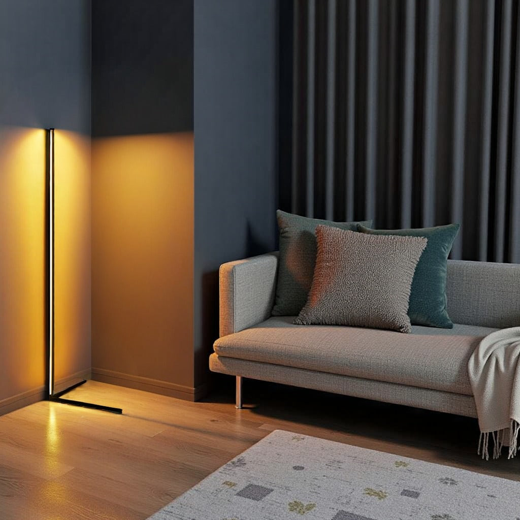 Lampa z ciepłym złotym światłem w kącie salonu, obok szarej sofy z poduszkami i dywanu 11