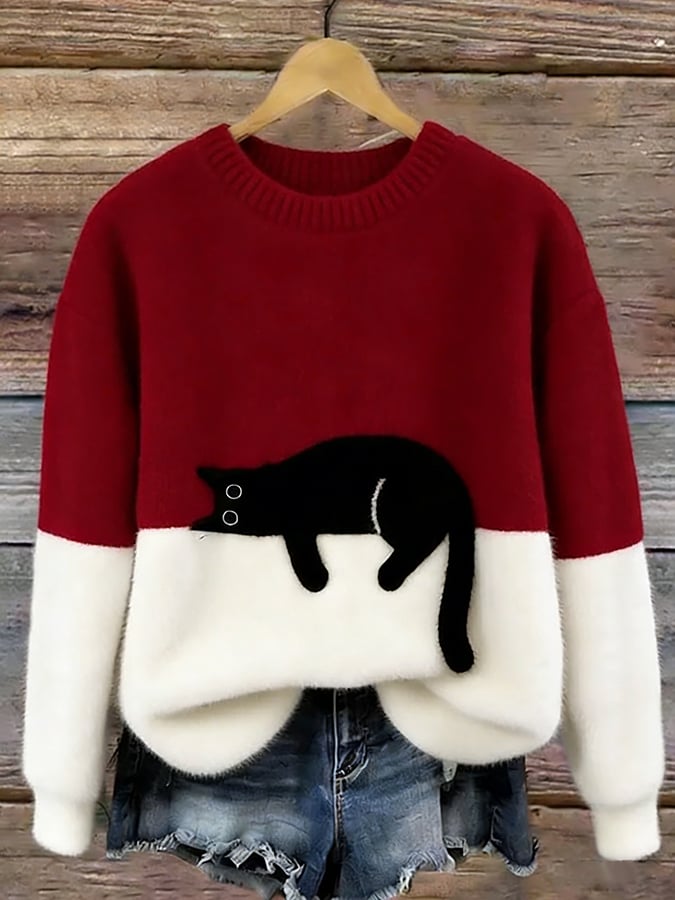 Puszysty sweter w kolorze czerwonym z białym dołem i czarnym kotem, na drewnianym wieszaku 6