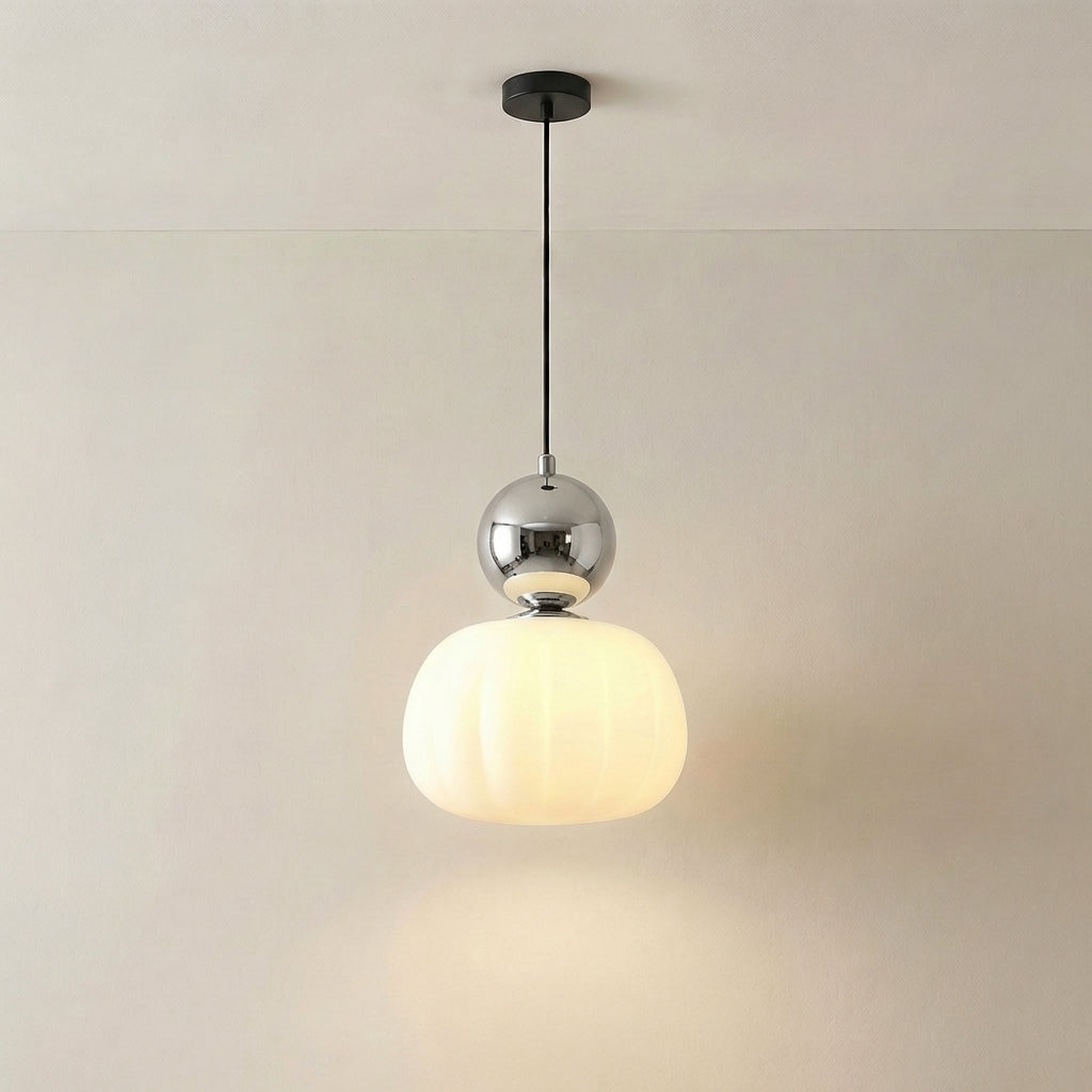Pojedyncza lampa z chromowaną srebrzystą kulą nad świecącym ryflowanym kloszem, zawieszona na czarnym kablu 6