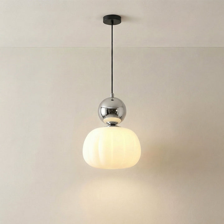 Pojedyncza lampa z chromowaną srebrzystą kulą nad świecącym ryflowanym kloszem, zawieszona na czarnym kablu 6