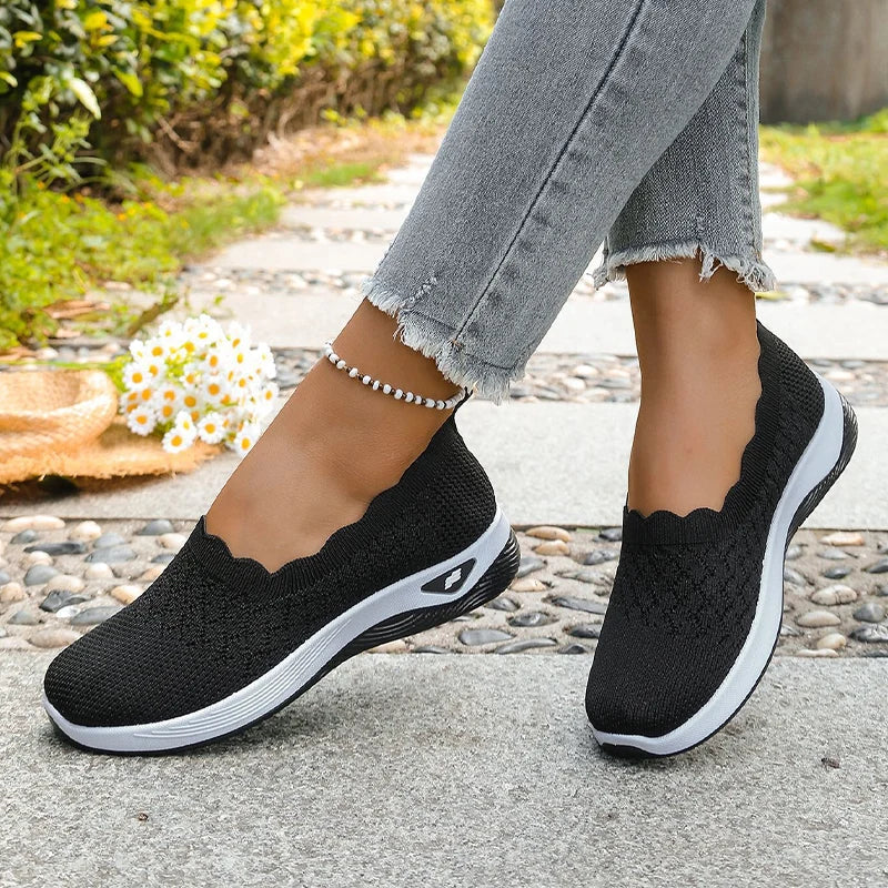 Czarne buty z falowaną cholewką na nogach w jeansach, na kamiennej ścieżce 14
