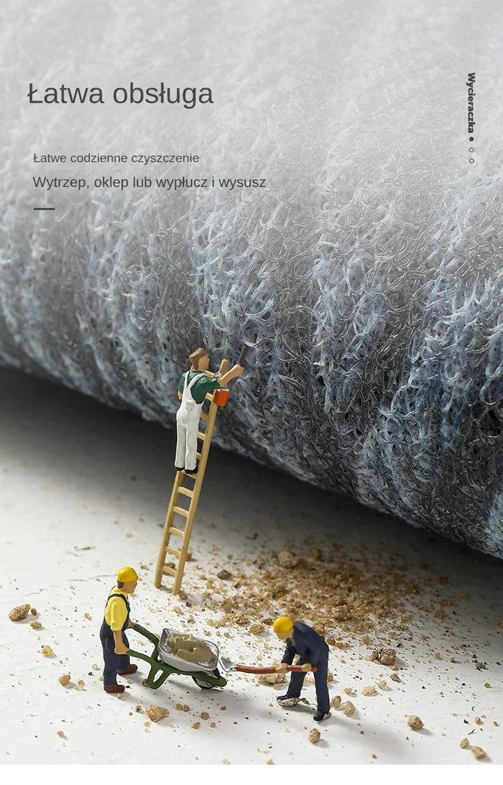 Zbliżenie na kłębiastą, oczkową fakturę wycieraczki, miniaturowe figurki sprzątają piasek spod maty 12
