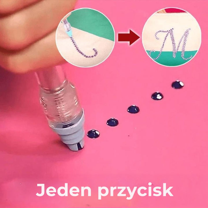 Pisak z przezroczystą końcówką przykłada pojedyncze ciemne kryształki na różowym tle, w kółkach powstająca litera z cyrkonii 3