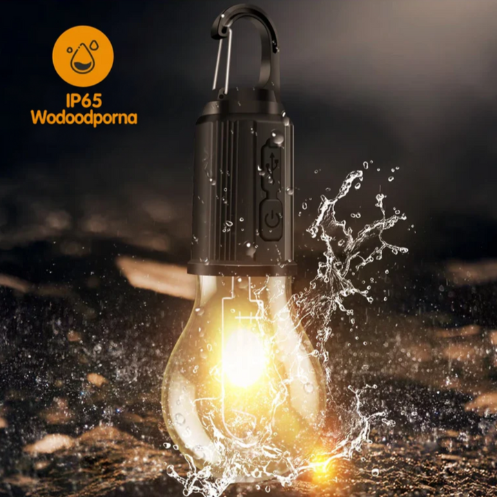 Lampa ochlapana wodą na mokrej ziemi, pokazująca odporność na wodę, z przyciskami na obudowie 9
