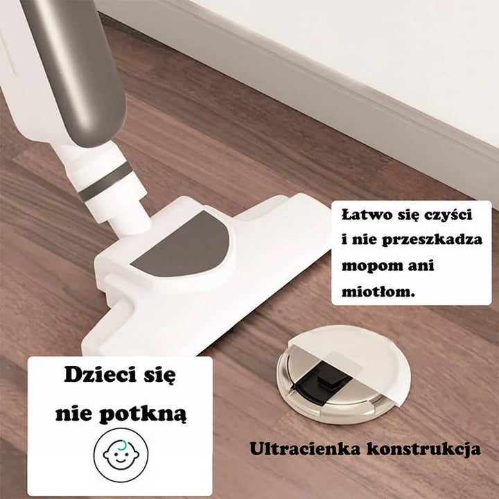 Płaski okrągły odbojnik na drewnianej podłodze obok odkurzacza, pokazujący, że nie przeszkadza w sprzątaniu 2