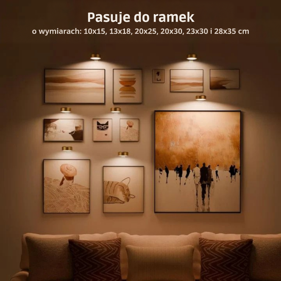 Ściana z galerią obrazów w różnych rozmiarach, każdy oświetlony małą złotą lampą, nad kanapą 2