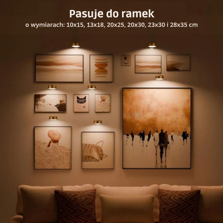 Ściana z galerią obrazów w różnych rozmiarach, każdy oświetlony małą złotą lampą, nad kanapą 2