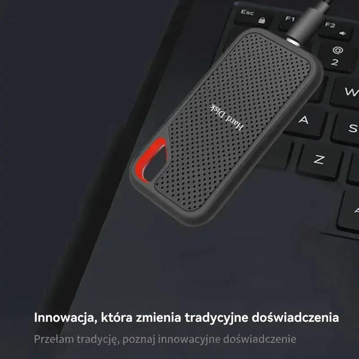 Dysk z podłączonym kablem leży na klawiaturze laptopa, widok z góry 2