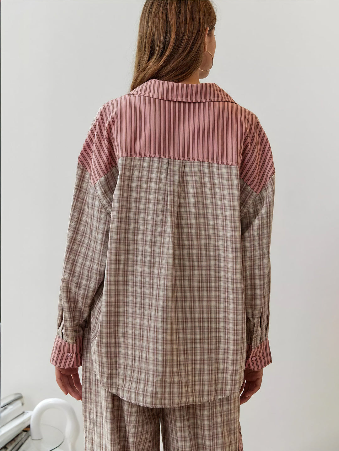 Tył różowo-beżowej kraciastej koszuli z paskowaną karczystą częścią na plecach i paskowanymi mankietami zapinanymi na guziki. 8