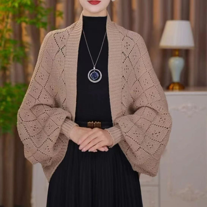 Modelka w beżowym kardiganie z ażurową dzianiny w romby i ściągaczem przy przodzie 5