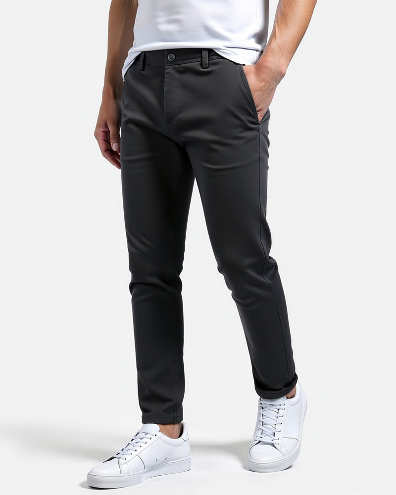 Ciemnoszare chinosy na modelu w białym t-shircie i białych sneakersach, ujęcie z boku, nogawki lekko podwinięte. 6