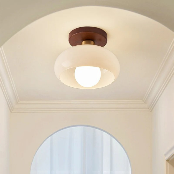 Mniejsza lampa z kremowym szklanym kloszem i mosiężnym łącznikiem pod łukowym sufitem korytarza 3