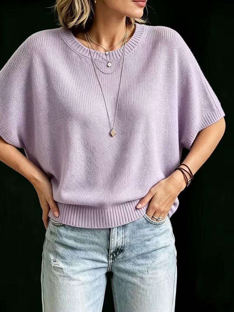 Liliowy dzianinowy top z przodu na modelce z rękami w kieszeniach dżinsów, krótki luźny fason. 11