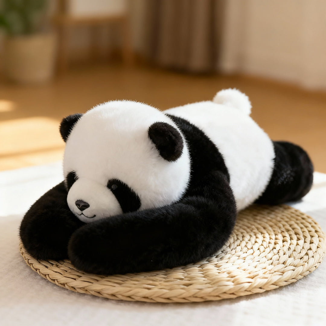 Czarno-biała pluszowa panda leży na plecionej słomianej podkładce, a jej długie czarne ramiona są złożone pod głową. 1