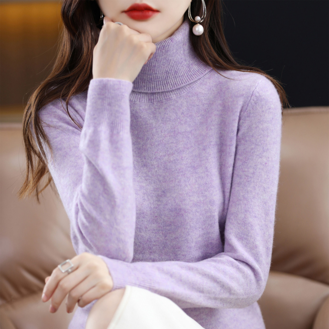 Liliowy melanżowy sweter z golfem na modelce, która podpiera brodę dłonią, siedząc na kanapie. 6