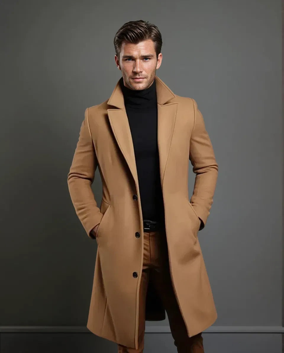 Pełna sylwetka modela w płaszczu w kolorze camel do kolan, z czarnym golfem, ciemnym paskiem i brązowymi spodniami. 5