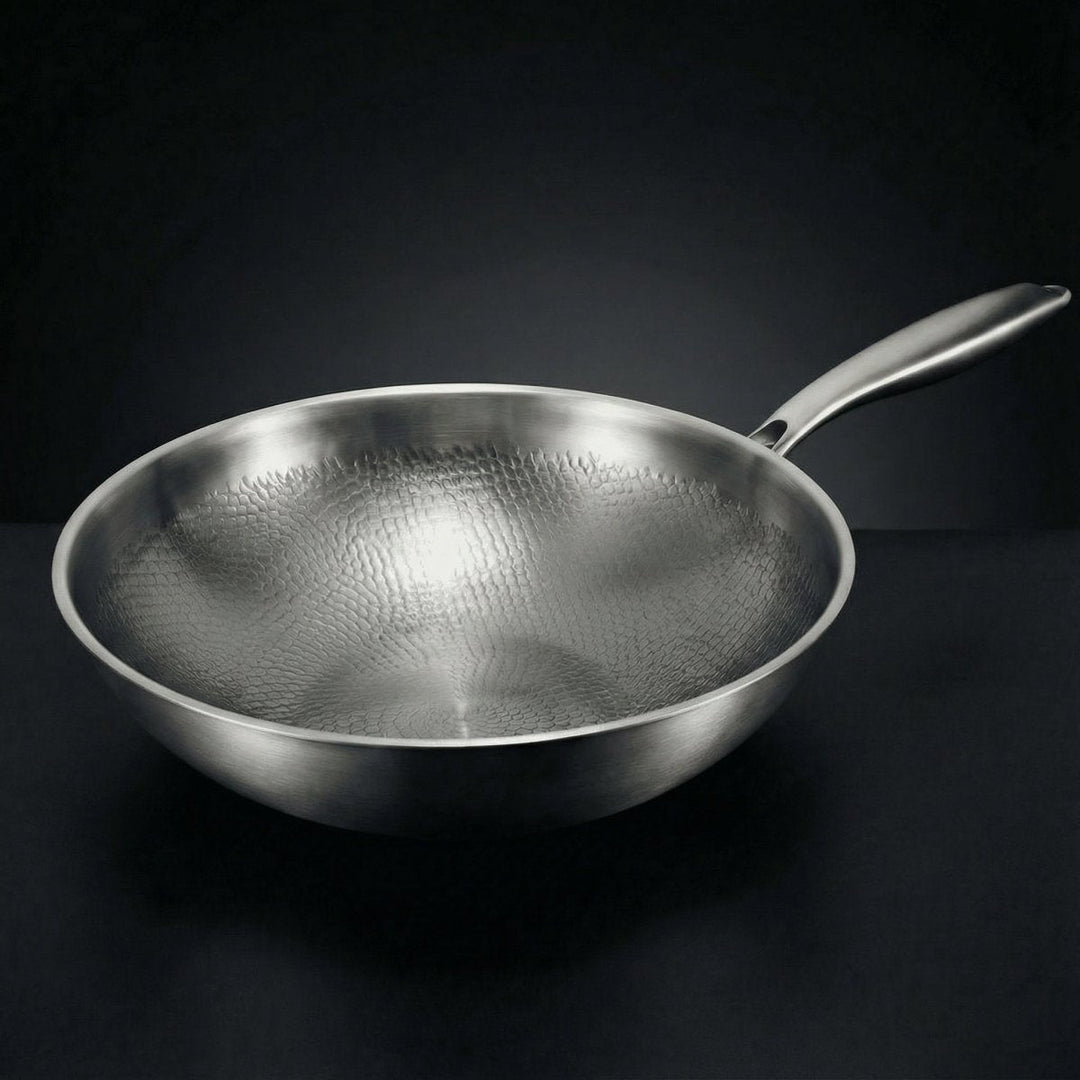 Pusty wok widziany z boku pod kątem, z młotkowaną fakturą wnętrza i metalowym uchwytem, na ciemnym tle. 1